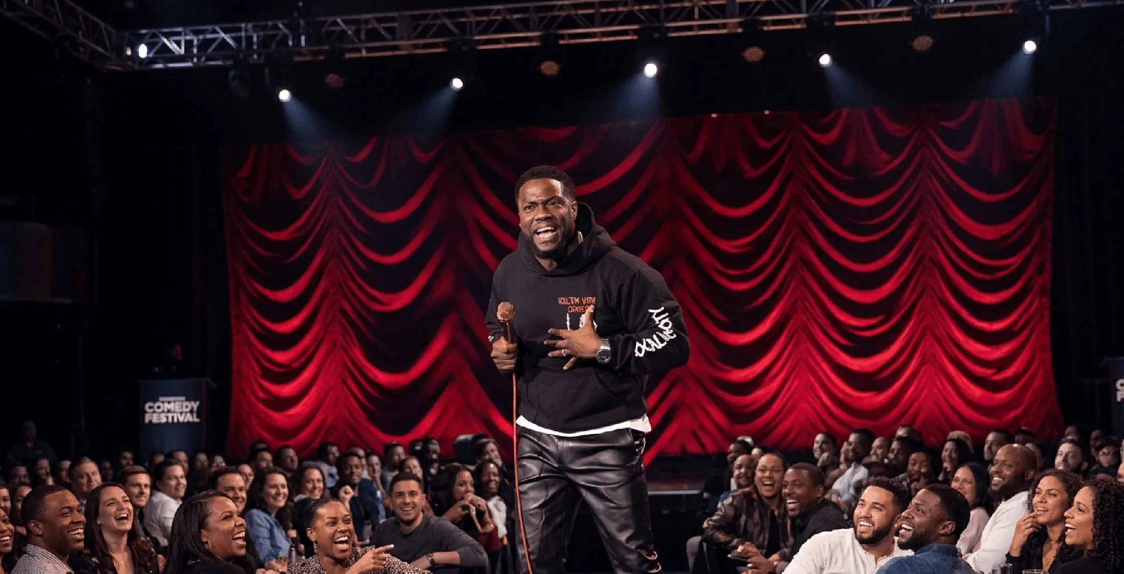 Reality Check Kevin Hart black hoodie with gothic skull graphics, red “Kill ’Em With Comedy” text, tour-inspired streetwear design, front view