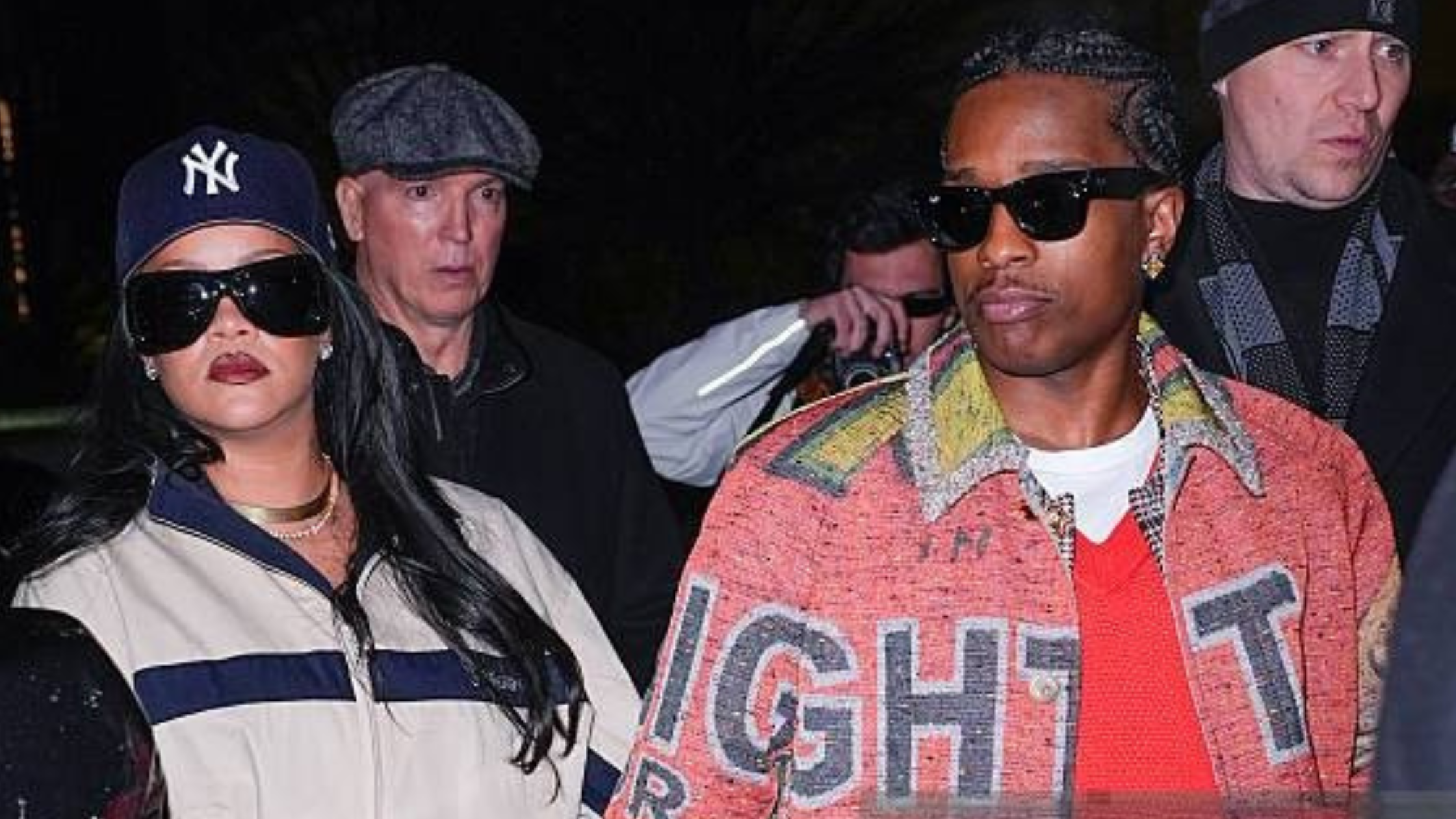 Rihanna wears a stylish cream windbreaker jacket, adding a pop of color to the New York City street night.