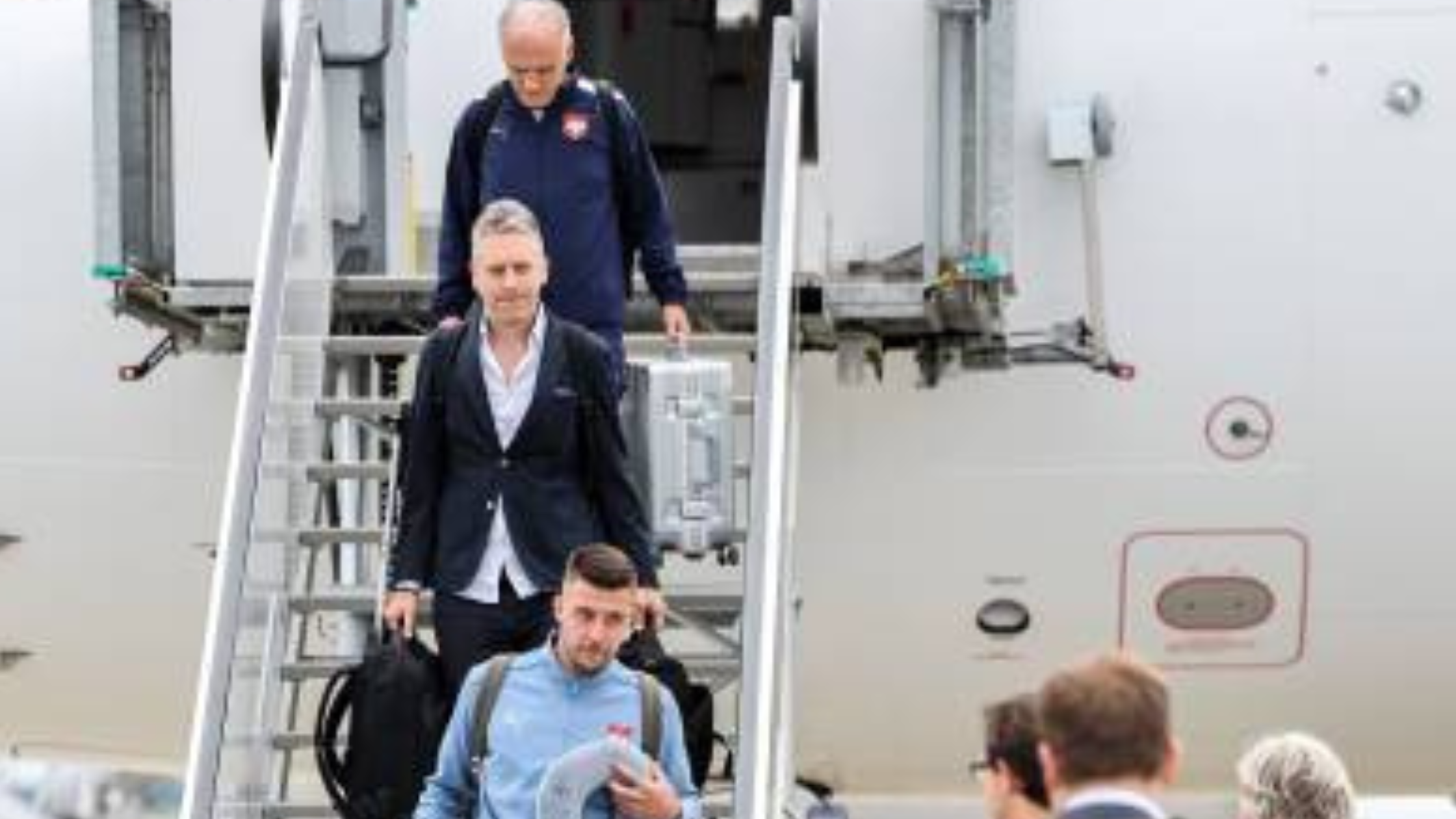 Serbia national football team players wearing light blue and navy track jackets with Puma logo and Serbian crest at UEFA Euro 2024 arrival in Munich.