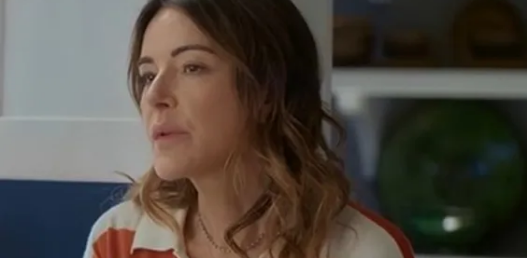 Christa Miller rainbow multicolor striped polo sweatshirt from Shrinking Season 3 featuring cream collar, colorful horizontal stripes, and relaxed rugby style