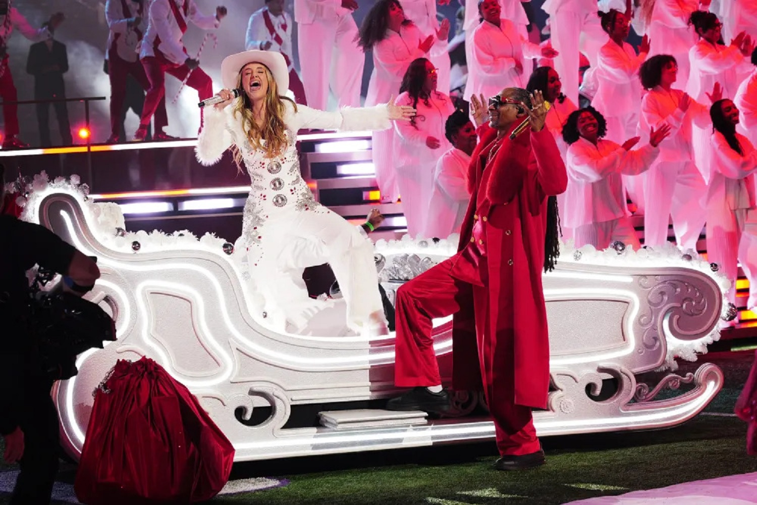 Snoop Dogg wearing a fire engine-red wool coat with oversized white fur collar during NFL Christmas Day 2025 halftime show