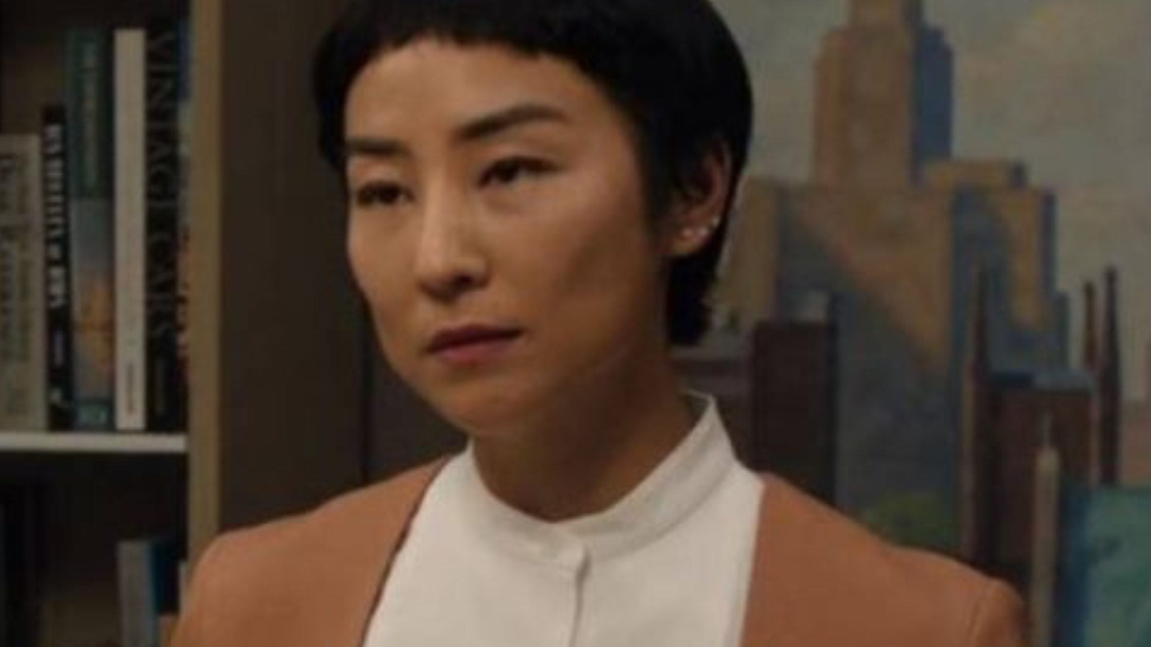 The Morning Show star Greta Lee wears a structured grey blazer as Stella Bak, adding powerful executive style to the Apple TV drama.