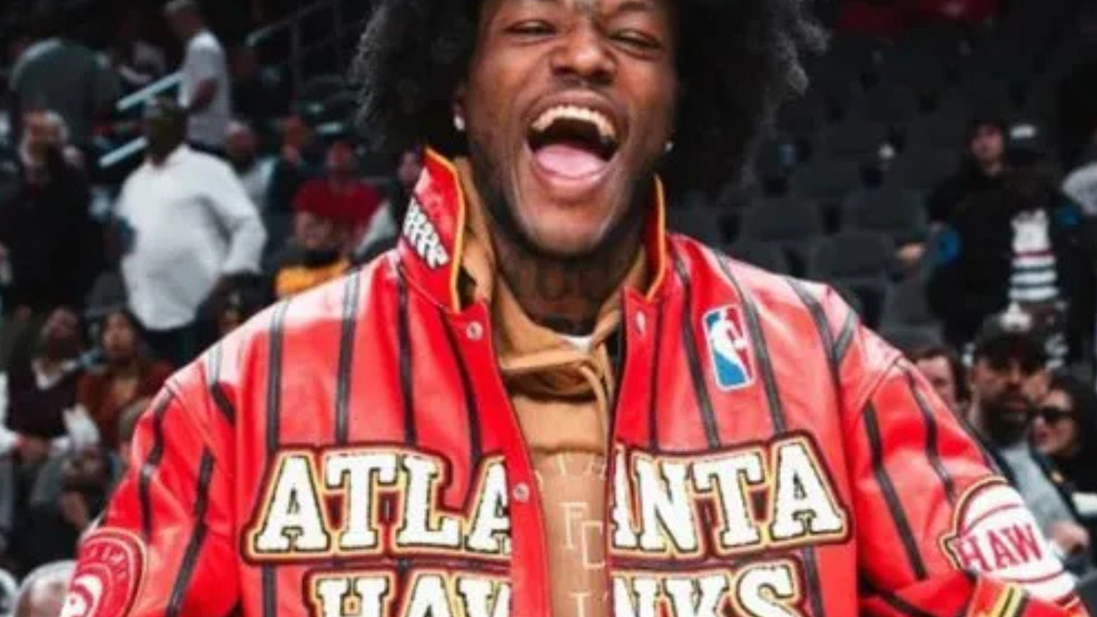 Athlete wearing the Atlanta Hawks Vegan Leather Jacket in white with geometric reflective graphics and a hooded windbreaker design.