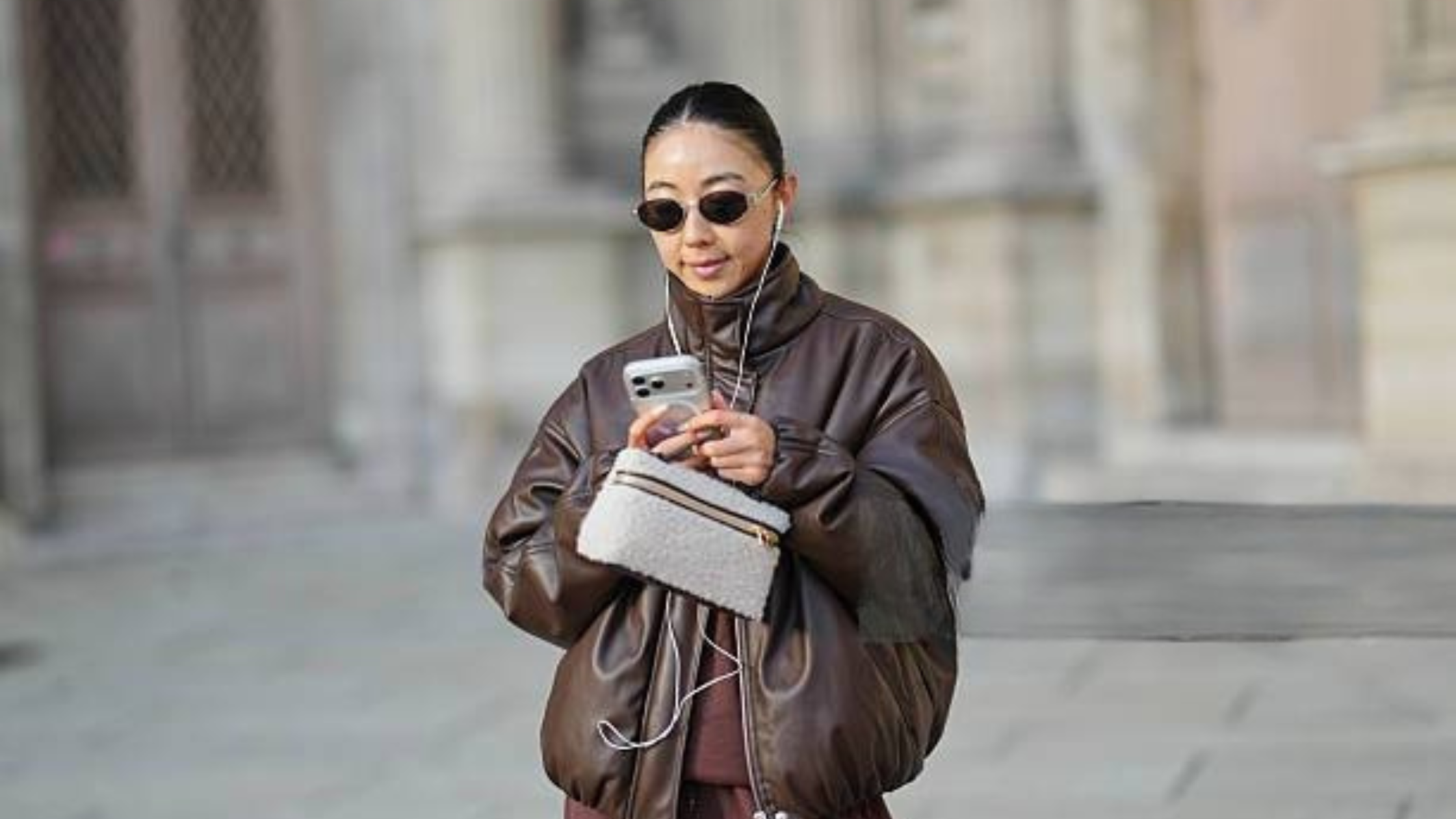 Street style star Yuwei Zhangzou wears a stylish brown oversized bomber leather jacket, adding bold elegance to the Paris fashion scene.